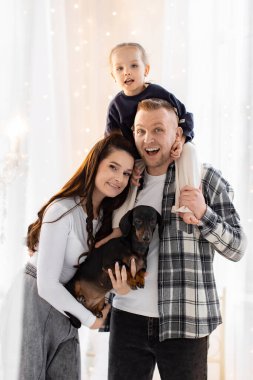 Mutlu bir aile birlikte poz verir, bir baba, anne, kız, ve onların sevimli dachshund köpekleri, yürek ısıtan bir sahne yaratır..