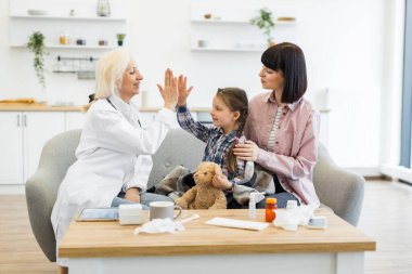 Bir doktor sağlık kontrolünden sonra genç bir kızla kutlama yapar. Annesiyle birlikte. Olumlu ve güven verici bir atmosfer yaratır..