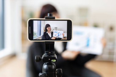 Akıllı telefon kurulumu ile kaydedilirken iş grafikleri ve büyüme analizleri sunan beyaz bir kadın