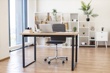 Parlak ve havadar bir ev ofisinde masa, sandalye ve raf ünitesi bulunur. Uzaktan çalışma ve yaratıcı projeler için mükemmeldir.