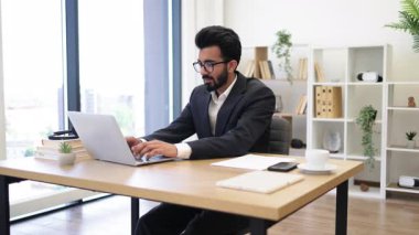 Hintli bir işadamı kollarını kaldırıp başarısını kutluyor.