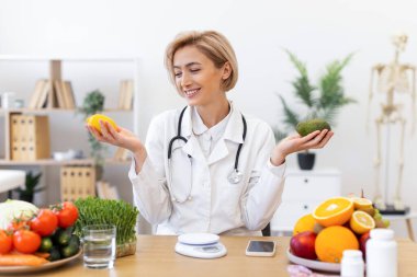 Gülümseyen bir beslenme uzmanı elinde bir limon ve avokado tutar ve taze ürünlerle sağlıklı beslenmeyi teşvik eder..