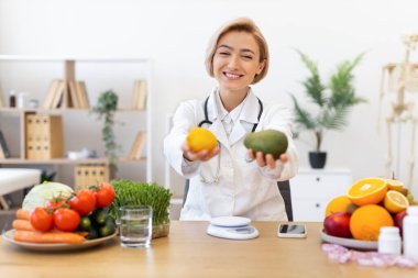 Gülümseyen bir diyet bir limon ve avokado tutar, klinik ortamında sağlıklı beslenme ve beslenmeyi teşvik eder..