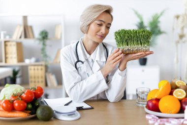 Bir beslenme uzmanı sağlıklı gıda seçenekleriyle çevrili taze lahanaları inceleyerek dengeli bir diyeti teşvik eder..