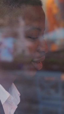 Perspective african man in stylish suit drinking coffee and working at cafe. Confident young businessman resting during a break.