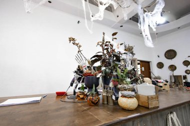 Bir tezgah Cadılar Bayramı süslemeleriyle süslenir. Örümcek ağları, balkabakları ve iskelet eller de dahil.