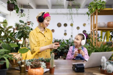 Bir kadın ve bir kız, bitkilerin ve müziğin tadını çıkarıyorlar.