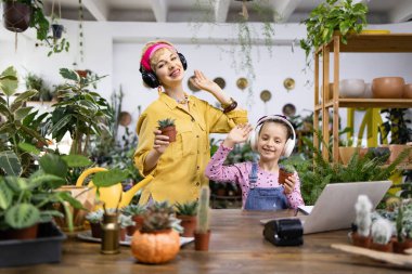 Bir anne ve kızı birlikte müzik dinlerken bitkilerinin keyfini çıkarırlar, neşeli bir an yaratırlar.
