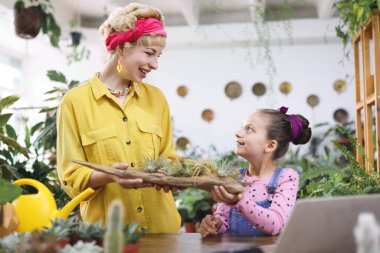 Bir kadın ve genç bir kız hava bitkilerinin gösterisine hayran kalarak bir anı paylaşıyorlar.