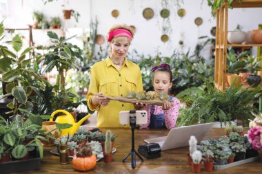 Bir kadın ve bir kız bir fabrikada hava santralleri kuruyorlar, sosyal medya için bir video çekiyorlar.