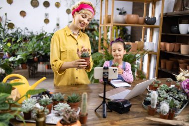 Bir kadın ve bir kız, bir fabrikadaki lezzetler hakkında bir video çekiyorlar. Eğitici içerik yaratıyorlar.