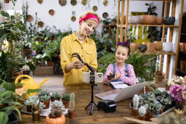 Bir anne ve kız, çevrimiçi seyircileri için bir bahçıvanlık dersi hazırlamak için bir araya gelirler.