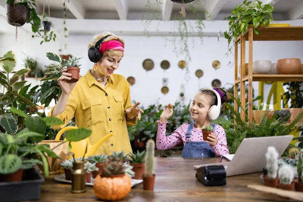 Bir anne ve kız, çiçeklerini parlak ve davetkar bir yerde saklarken müziğin keyfini çıkarırlar.