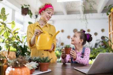 Bir anne ve kız, bitkileriyle ve bahçeleriyle ilgilenirken birlikte bir anın tadını çıkarırlar.