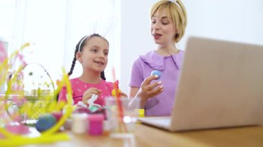 Bir anne ve kızı Paskalya yumurtası süsleme seansının keyfini çıkarırlar.