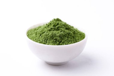 Green vegetables powder on white cup at white background, copyspace