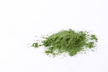 Green vegetables powder on white cup at white background, copyspace