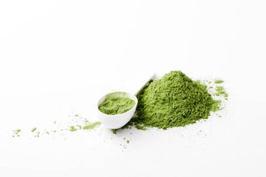 Green vegetables powder on white cup at white background, copyspace