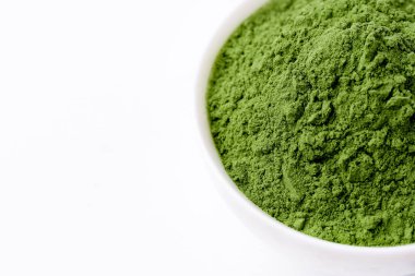 Green vegetables powder on white cup at white background, copyspace