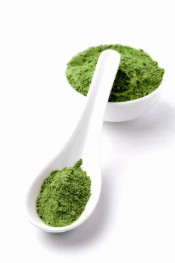 Green vegetables powder on white cup at white background, copyspace