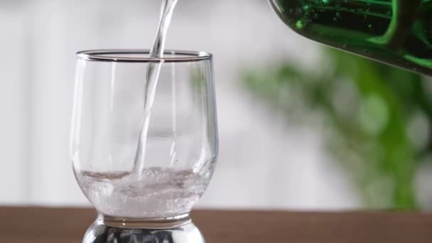 Sprankelend Water Dat Van Groene Plastic Fles Naar Glas Stroomt — Stockvideo
