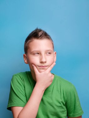 Ağzı açık duran duygusal sevimli çocuğun stüdyo çekimi şaşırmış ve şok olmuştu, gerçek duygularını gösteriyordu. Mavi arkaplanda portre 