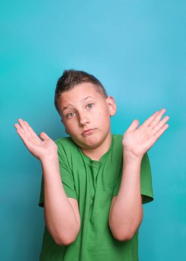 Duygusal açıdan sevimli çocuğun gerçek duygularını gösteren bir stüdyo çekimi. Mavi arkaplanda portre 