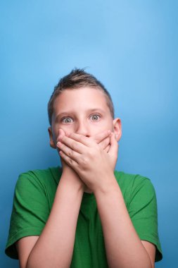 Duygusal açıdan sevimli çocuğun gerçek duygularını gösteren bir stüdyo çekimi. Mavi arkaplanda portre 