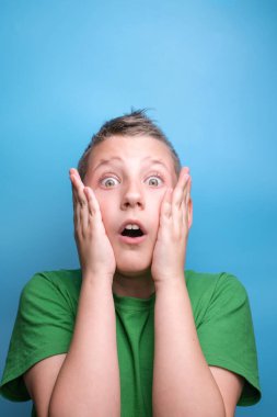 Duygusal açıdan sevimli çocuğun gerçek duygularını gösteren bir stüdyo çekimi. Mavi arkaplanda portre 