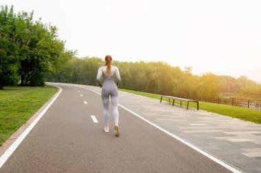 Kadın tozluklu ve üst düzey asfalt yol parkı işletiyor. Sağlıklı yaşam tarzı kavramı. Aktif ve atletik kadın egzersizleri.