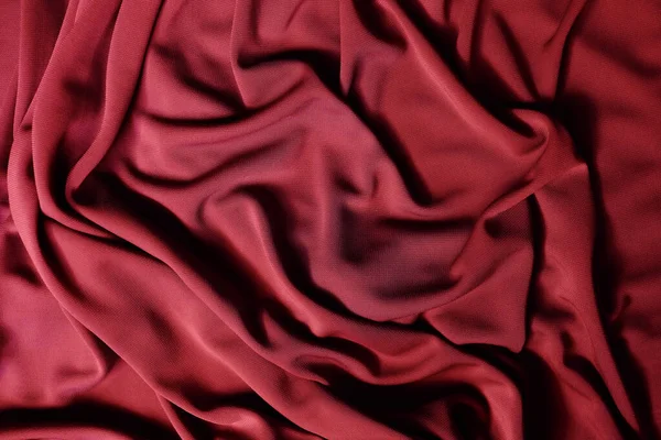 Smooth elegant red satin texture can use as abstract background. Luxurious background design. Closeup texture