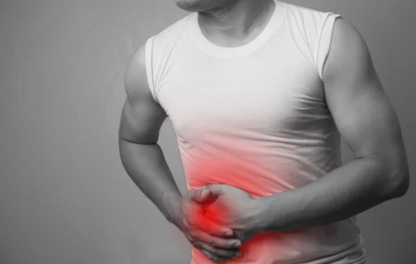 Abdominal Pain Man suffering from stomach ache ,appendix pain, an inflammation of the appendix over gray background. Black and white with a red accent