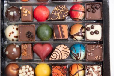 Bir sürü çikolatalı pralin, beyaz arka planda izole edilmiş çeşitli çikolatalı pralinlerin üst görüntüsü.,