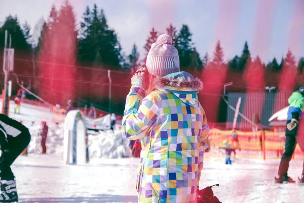 滑雪场，一个女孩看着滑雪者正在滑向的滑雪场 — 图库照片