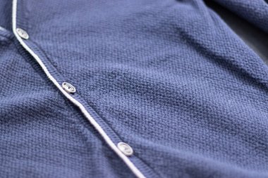 Yakından ahşap düğmeli bej bir kazak örülmüş. Güzel desenli, güzel örülmüş bir arka plan. Üst görünüm