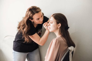 Makyöz gelin için makyaj yapıyor.,