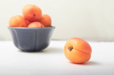 Masada olgun kayısılar var. Portakallı kayısı kasede meyve. Kayısı suyu besleyici..