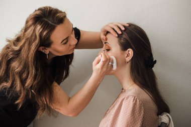 Makyöz gelin için makyaj yapıyor.,