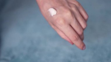 Krem süren genç bir kadının kolları. Güzel bayan eller stüdyoya yakın çekim. Yaşlanma, sağlık ve gençleşme karşıtı.