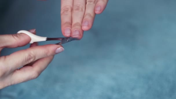 Een vrouw doet haar eigen manicure op haar handen thuis, nagel schaar, huidverzorging, vrouwelijke schoonheid. — Stockvideo