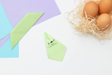 Yumurtalı çocuk paskalya tavşanı. 19. adım. Paskalya gazetesi adım adım. Mutlu tavşan yumurtayı tutuyor. Çocuk Sanatları Projesi, nakış, çocuklar için el işi, ilkbahar.