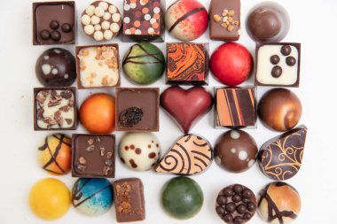 Bir sürü çikolatalı pralin, beyaz arka planda izole edilmiş çeşitli çikolatalı pralinlerin üst görüntüsü.,