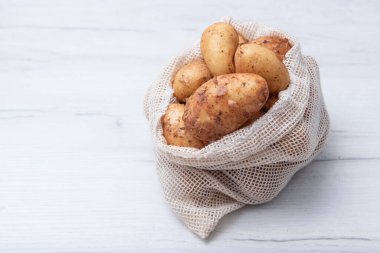 Çiğ organik patates. Bir torba dolusu patates. Çuval dolusu patates. Metin için boşluk,