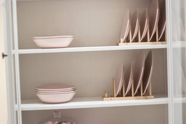 Storage stand with tableware and kitchen utensils indoors. ideas for storing and organizing space