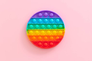 Stres önleyici oyuncağı patlat. Pembe arka plandaki çocuklar için yeni popüler silikon renkli anti-stres popit oyuncağı. Yukarıdan bak. Boşluğu kopyala.