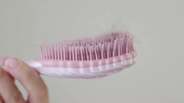 Tarak elinde ve saçı var. Saç dökülme sorunu, hormonal bozukluk, stres, diyet, kafa derisi ve saç ampülü hastalığı..