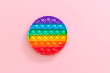 Stres önleyici oyuncağı patlat. Pembe arka plandaki çocuklar için yeni popüler silikon renkli anti-stres popit oyuncağı. Yukarıdan bak. Boşluğu kopyala