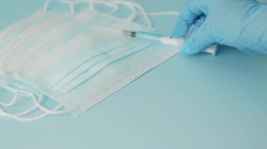 El, yüzeye birkaç tıbbi maske ve bir civa termometresi yerleştirir. Seçici atış.