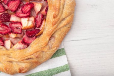 Elmalı çilekli turta, üst görüş kenarı, fotokopi alanı olan ahşap bir arka plan. Sonbahar yemekleri konsepti. Adım adım tarif galeti