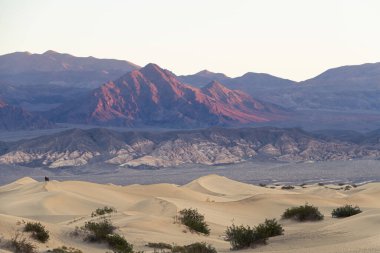 Ölüm Vadisi 'ndeki kum tepecikleri, Ölüm Vadisi Ulusal Parkı' nda güneş doğarken soba kuyularının yanında..